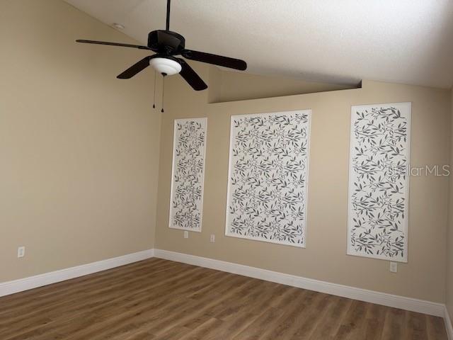 2551 Hunley Loop Kissimmee, FL 34743 - Photo 13 of 24 a view of empty room with wooden floor and fan