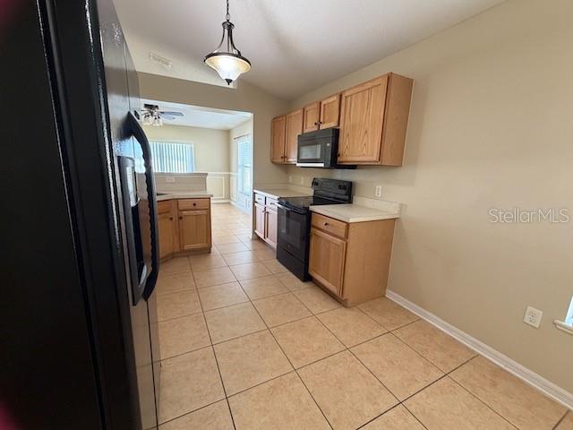 2551 Hunley Loop Kissimmee, FL 34743 - Photo 18 of 24 a kitchen with granite countertop a refrigerator and a stove top oven