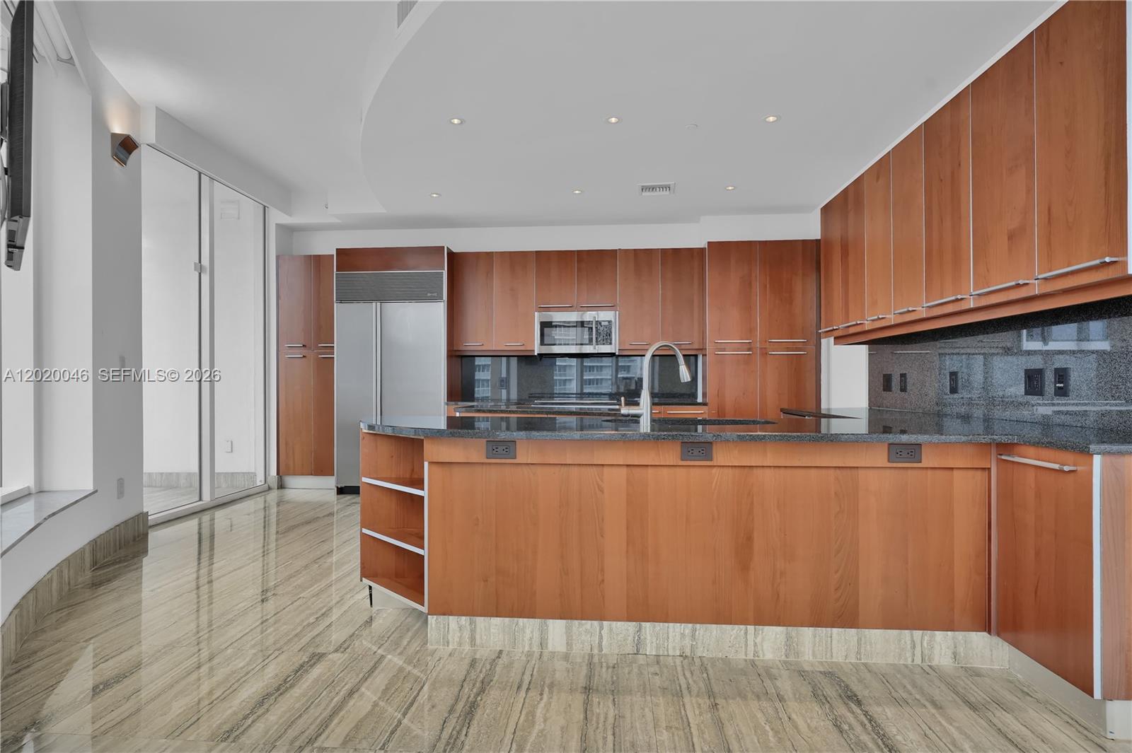 901 Brickell Key Boulevard, Unit 3204 Miami, FL 33131 - Photo 15 of 55 a kitchen with stainless steel appliances wooden floors and wooden cabinets
