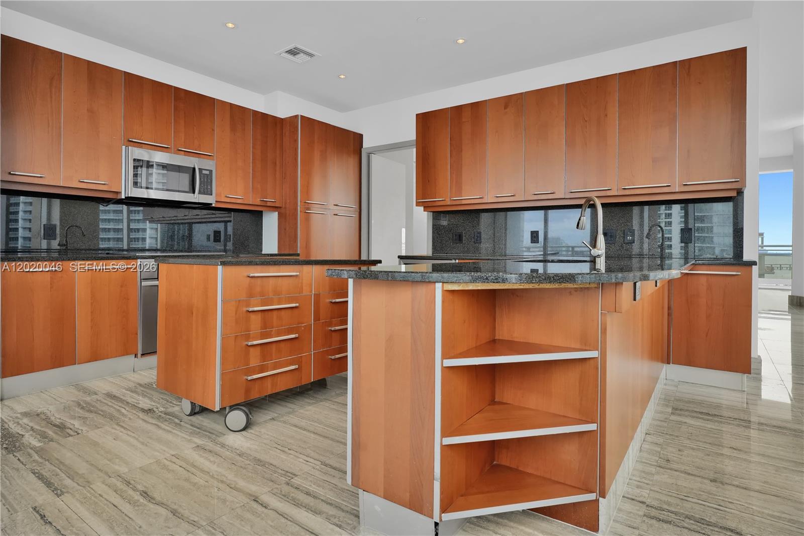 901 Brickell Key Boulevard, Unit 3204 Miami, FL 33131 - Photo 16 of 55 a kitchen with stainless steel appliances wooden cabinets and a wooden floor