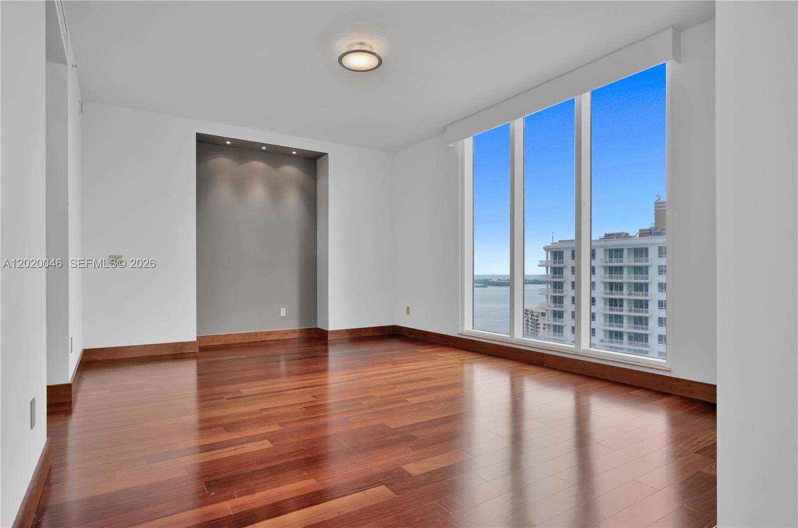 901 Brickell Key Boulevard, Unit 3204 Miami, FL 33131 - Photo 21 of 55 a view of an empty room with wooden floor and a window
