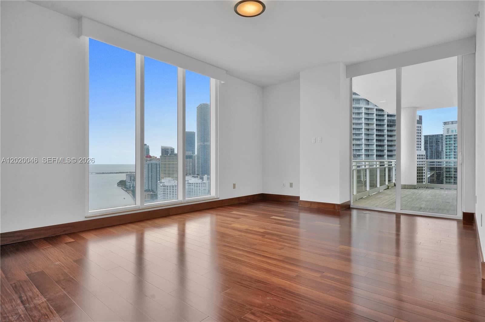 901 Brickell Key Boulevard, Unit 3204 Miami, FL 33131 - Photo 22 of 55 a view of a room with wooden floor and window