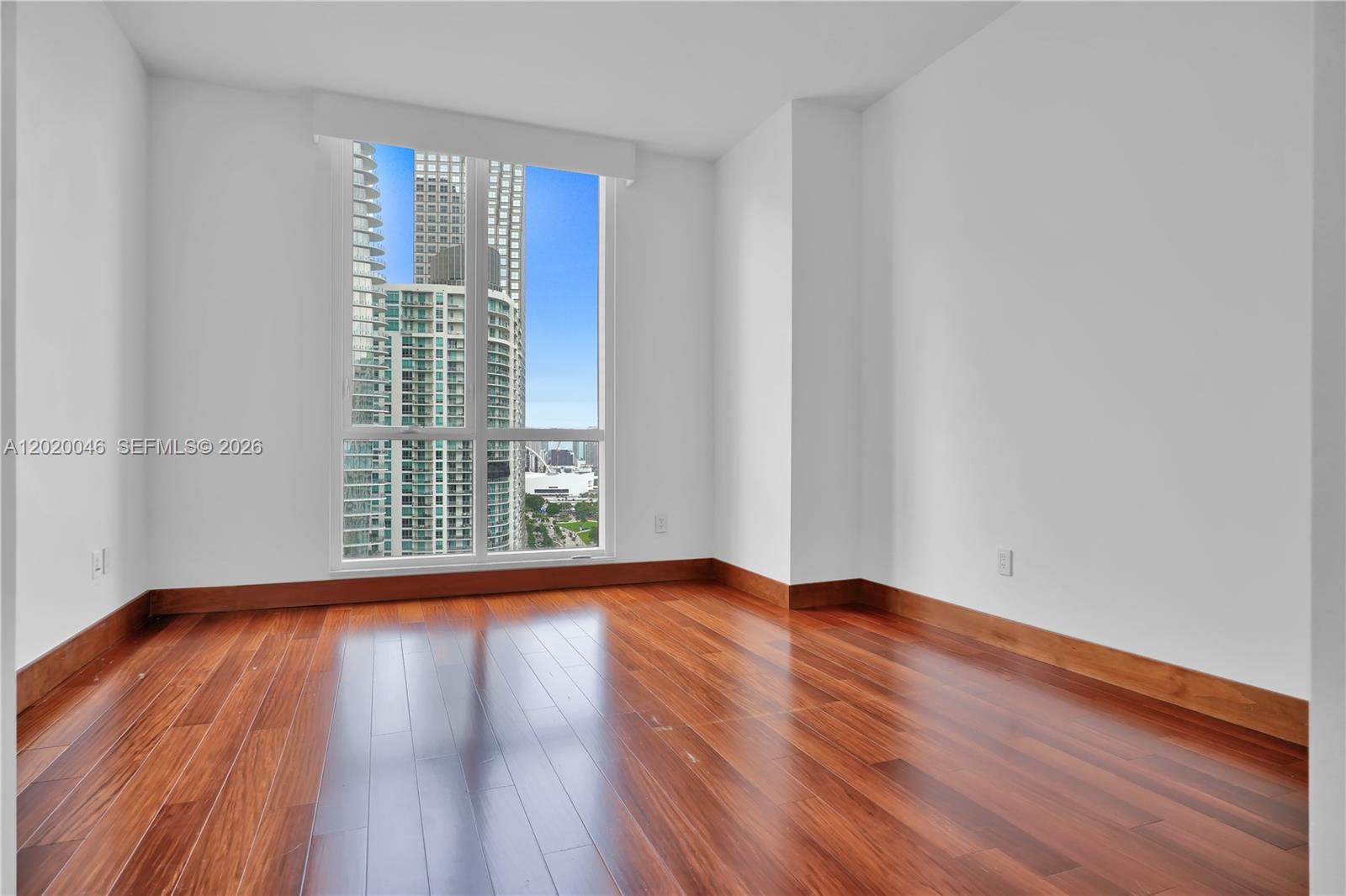 901 Brickell Key Boulevard, Unit 3204 Miami, FL 33131 - Photo 32 of 55 a view of an empty room with wooden floor and a window