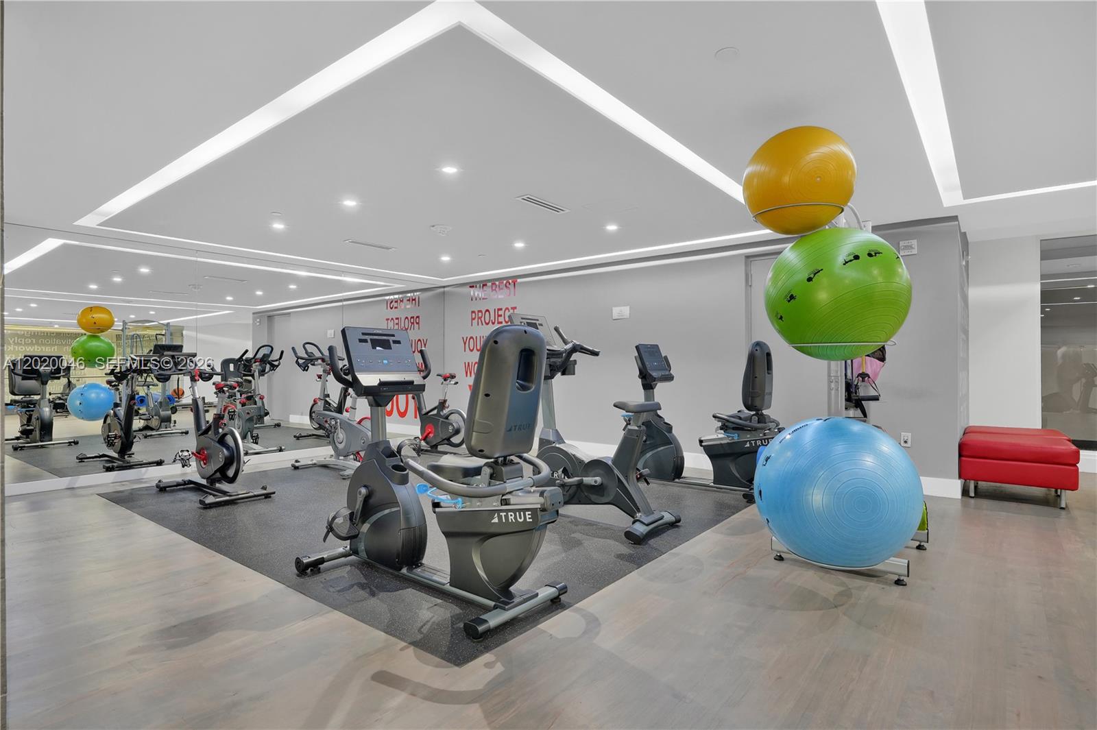 901 Brickell Key Boulevard, Unit 3204 Miami, FL 33131 - Photo 37 of 55 a room with gym equipment and mirrors
