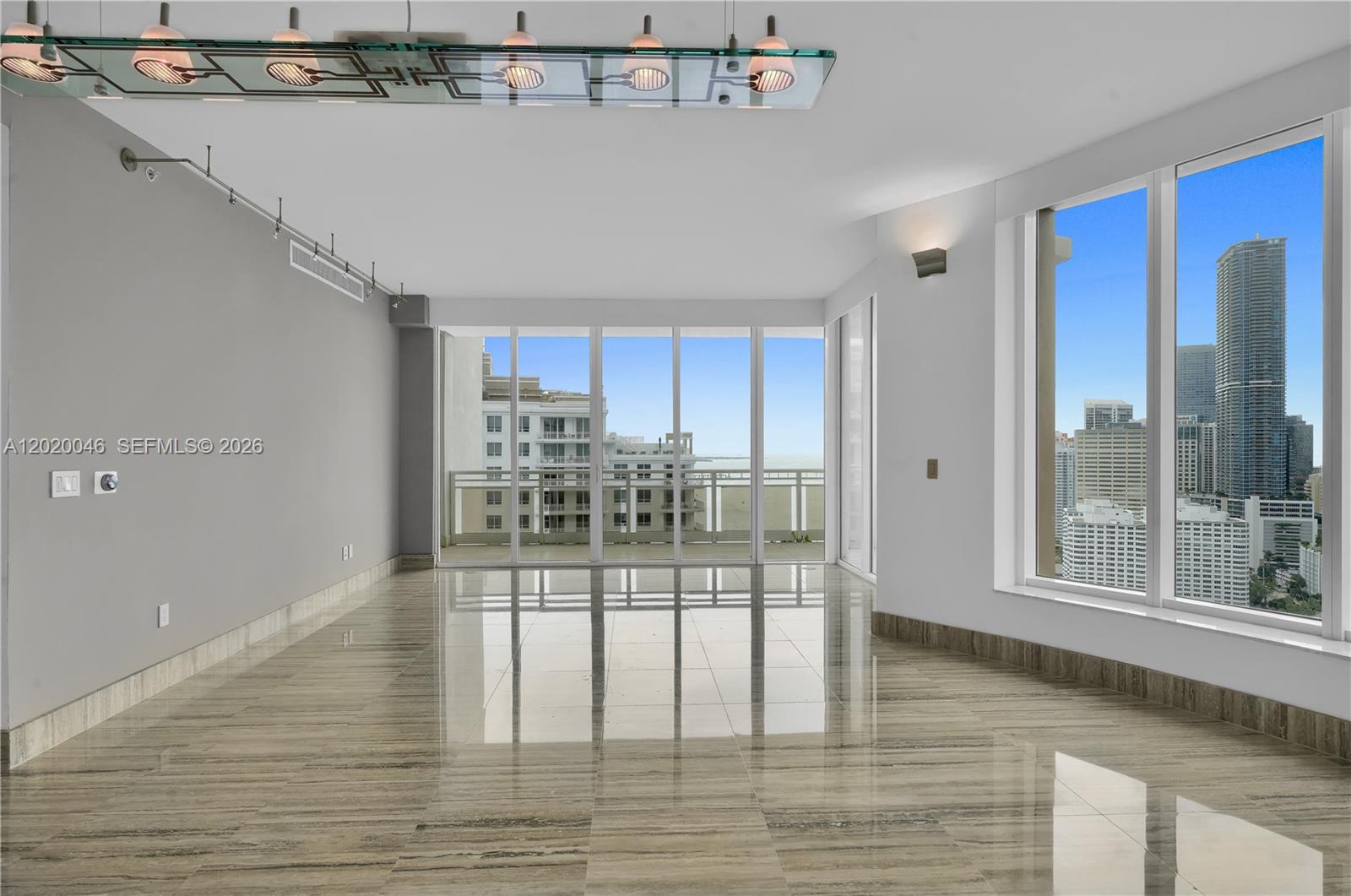 901 Brickell Key Boulevard, Unit 3204 Miami, FL 33131 - Photo 10 of 55 a room with wooden floor and glass door