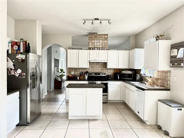 a kitchen with stainless steel appliances granite countertop a sink and cabinets