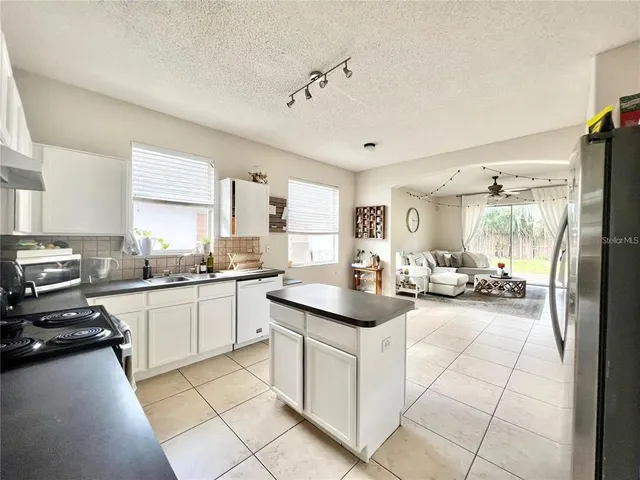 a kitchen with sink cabinets and stove top oven