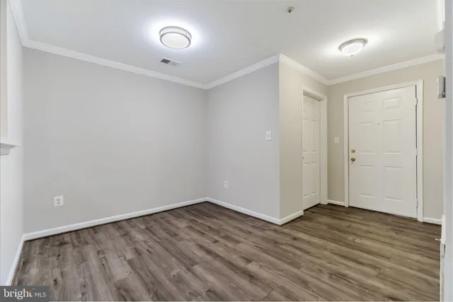 a view of an empty room with wooden floor