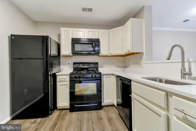 a kitchen with stainless steel appliances granite countertop a refrigerator stove and sink