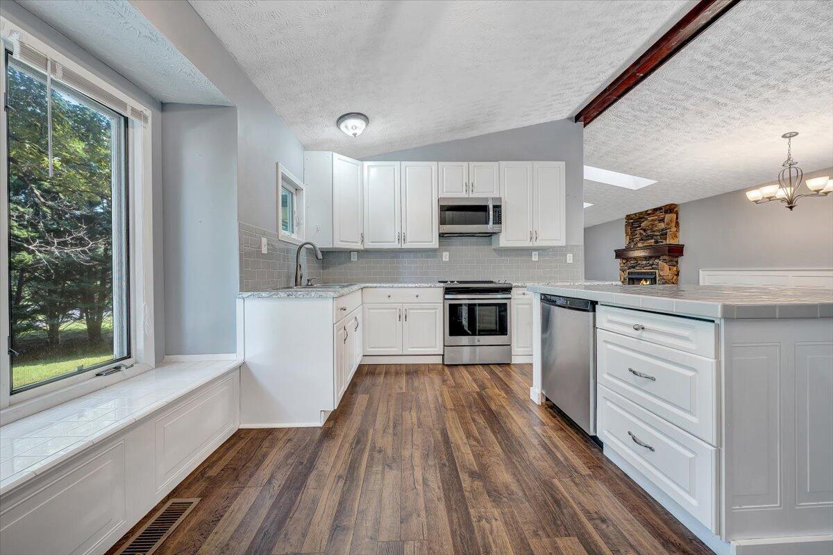 80 Walnut Landing Circle Hardy, VA 24101 - Photo 15 of 34 a kitchen with kitchen island wooden floors white cabinets and appliances