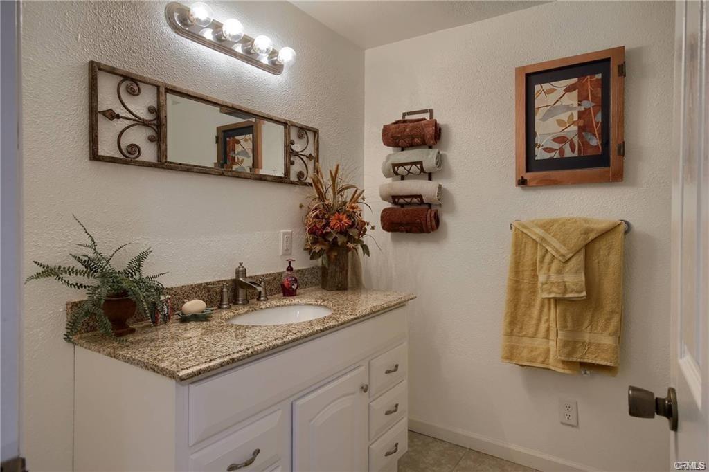 7428 Hornitos Road Hornitos, CA 95325 - Photo 23 of 46 a bathroom with a granite countertop sink and a mirror
