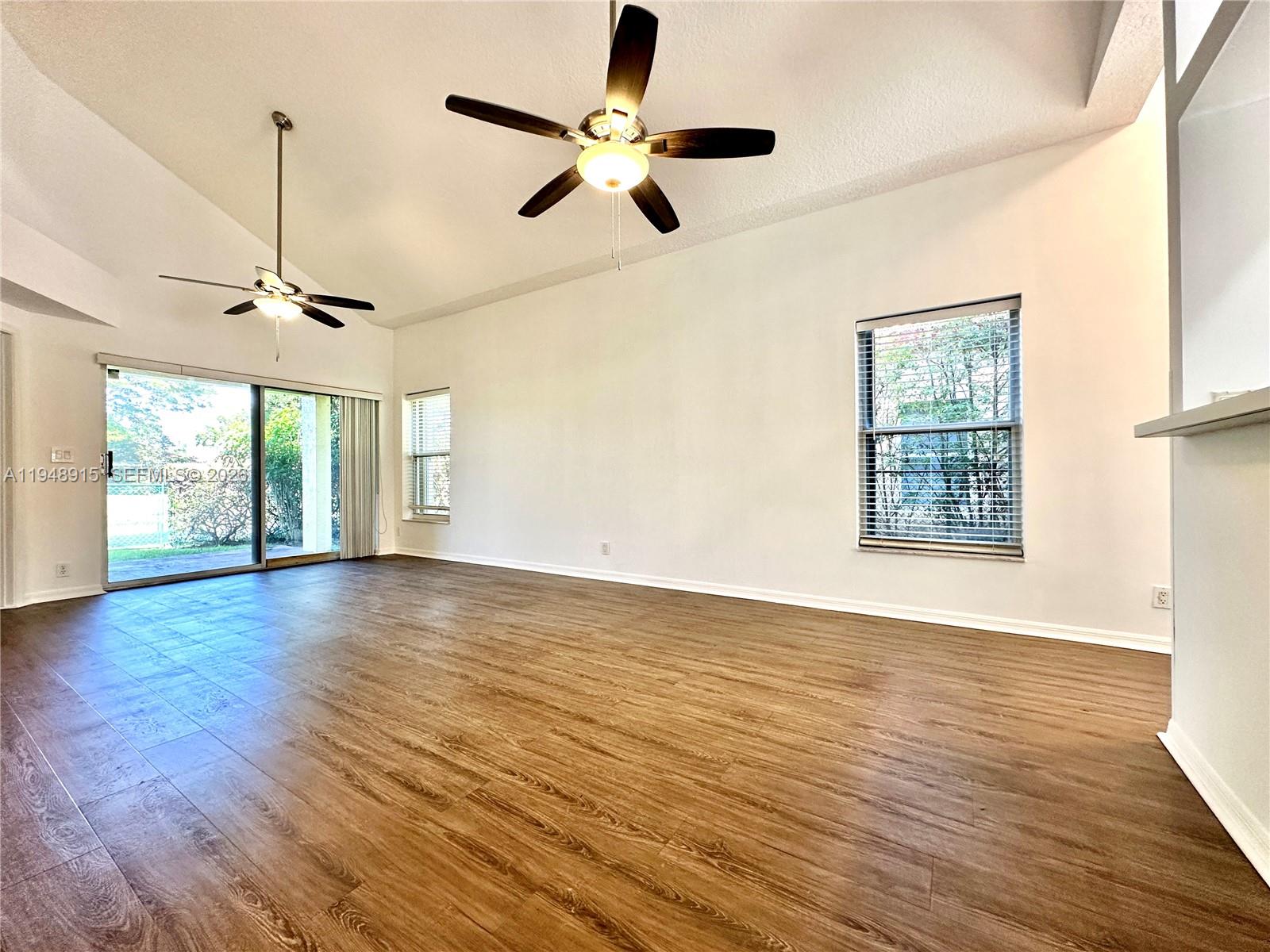 1013 Via Jardin Riviera Beach, FL 33418 - Photo 4 of 18 a view of an empty room with a window and wooden floor