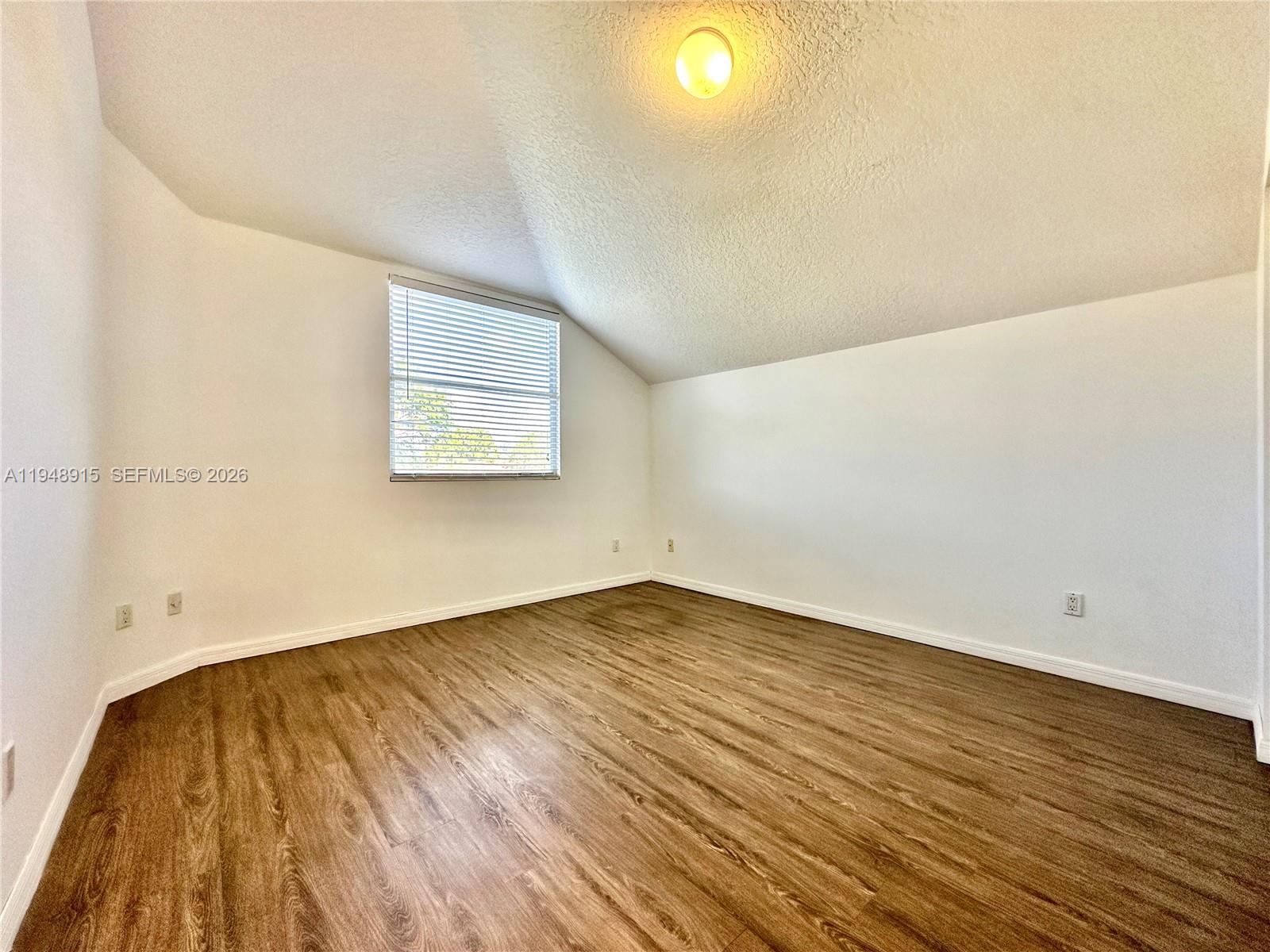 1013 Via Jardin Riviera Beach, FL 33418 - Photo 10 of 18 an empty room with wooden floor and windows