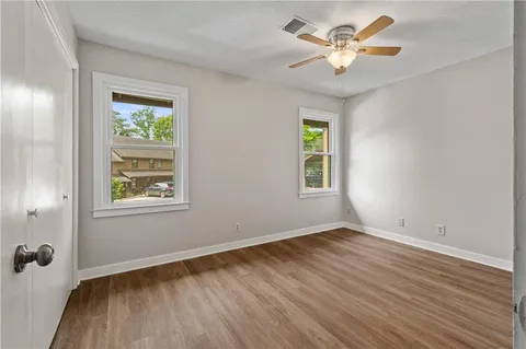 a view of an empty room with a window and wooden floor