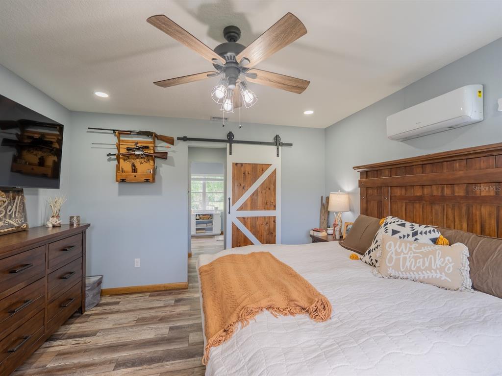 4381 Northeast 105th Place Anthony, FL 32617 - Photo 22 of 49 a bedroom with a bed and a flat screen tv