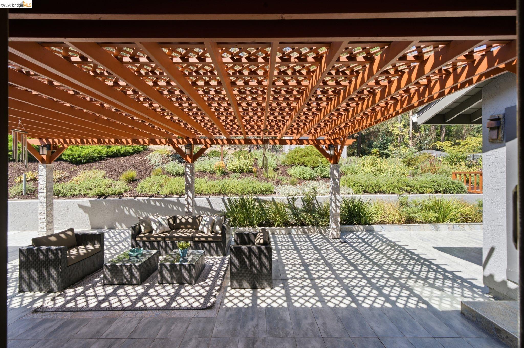 11133 Golf Links Road Oakland, CA 94605 - Photo 45 of 57 Expansive patio featuring a decorative wooden pergola, tiled flooring, and multiple support columns with stone detailing