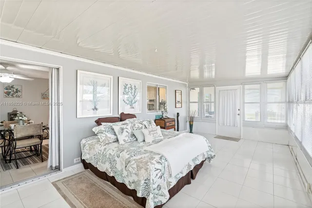 a large bed sitting in a bedroom next to a large window