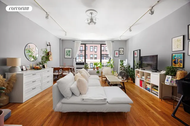 a living room with furniture a flat screen tv and a large window