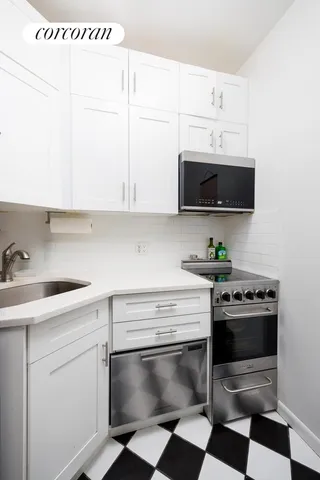 a kitchen with granite countertop white cabinets stainless steel appliances and a sink