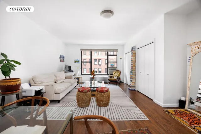 a living room with furniture floor to ceiling window and wooden floor