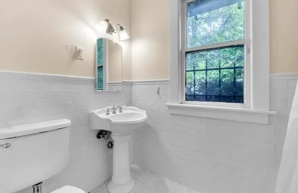 a bathroom with a sink a toilet and a mirror