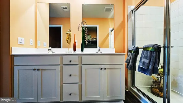 a bedroom with a bed a dresser and potted plants