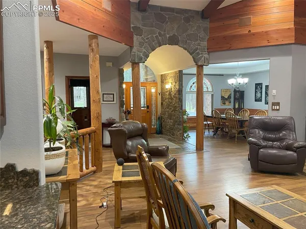 a living room with couches a dining table and chairs with wooden floor