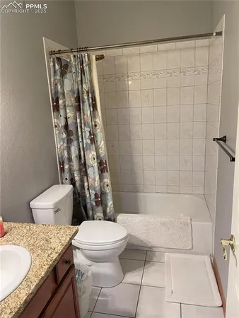 a bathroom with a granite countertop bathtub shower sink vanity and toilet