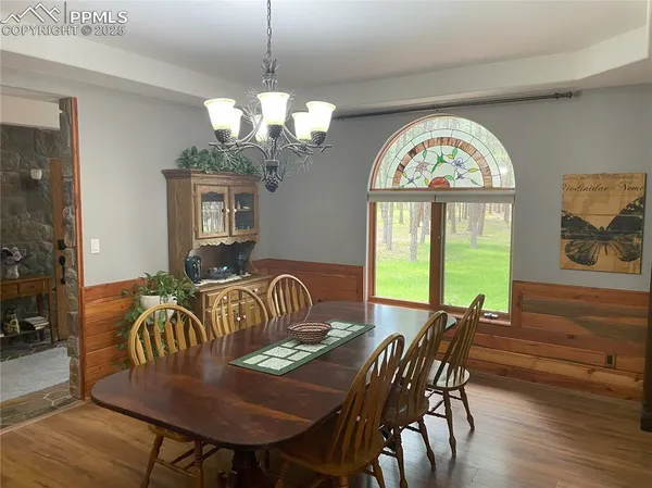a view of a dining room with furniture a chandelier and wooden floor