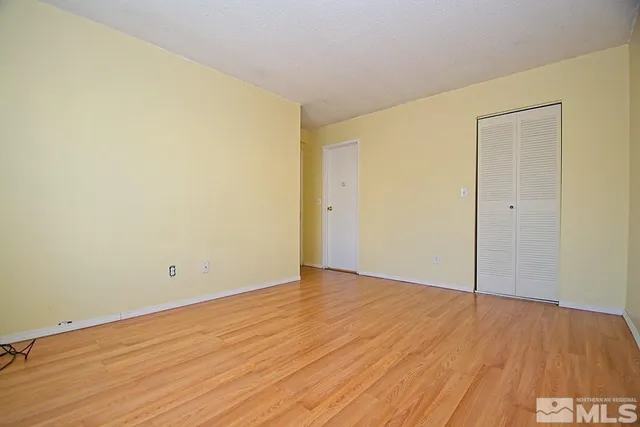 a view of an empty room with wooden floor