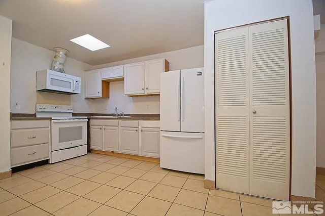 a kitchen with white cabinets and white appliances