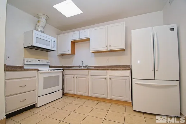 a kitchen with white cabinets and white appliances