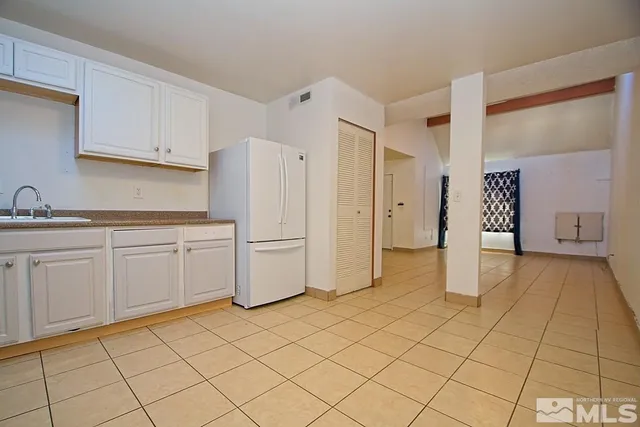 a kitchen with white cabinets and refrigerator