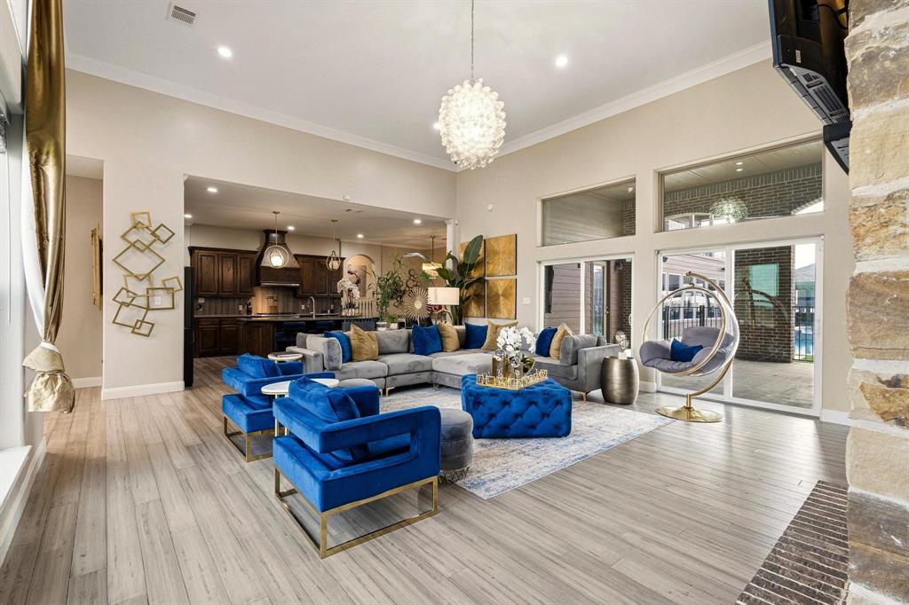 1517 Bennett Road Howe, TX 75459 - Photo 7 of 40 Living room featuring light wood-style floors, ornamental molding, suspended lighting, and a high ceiling