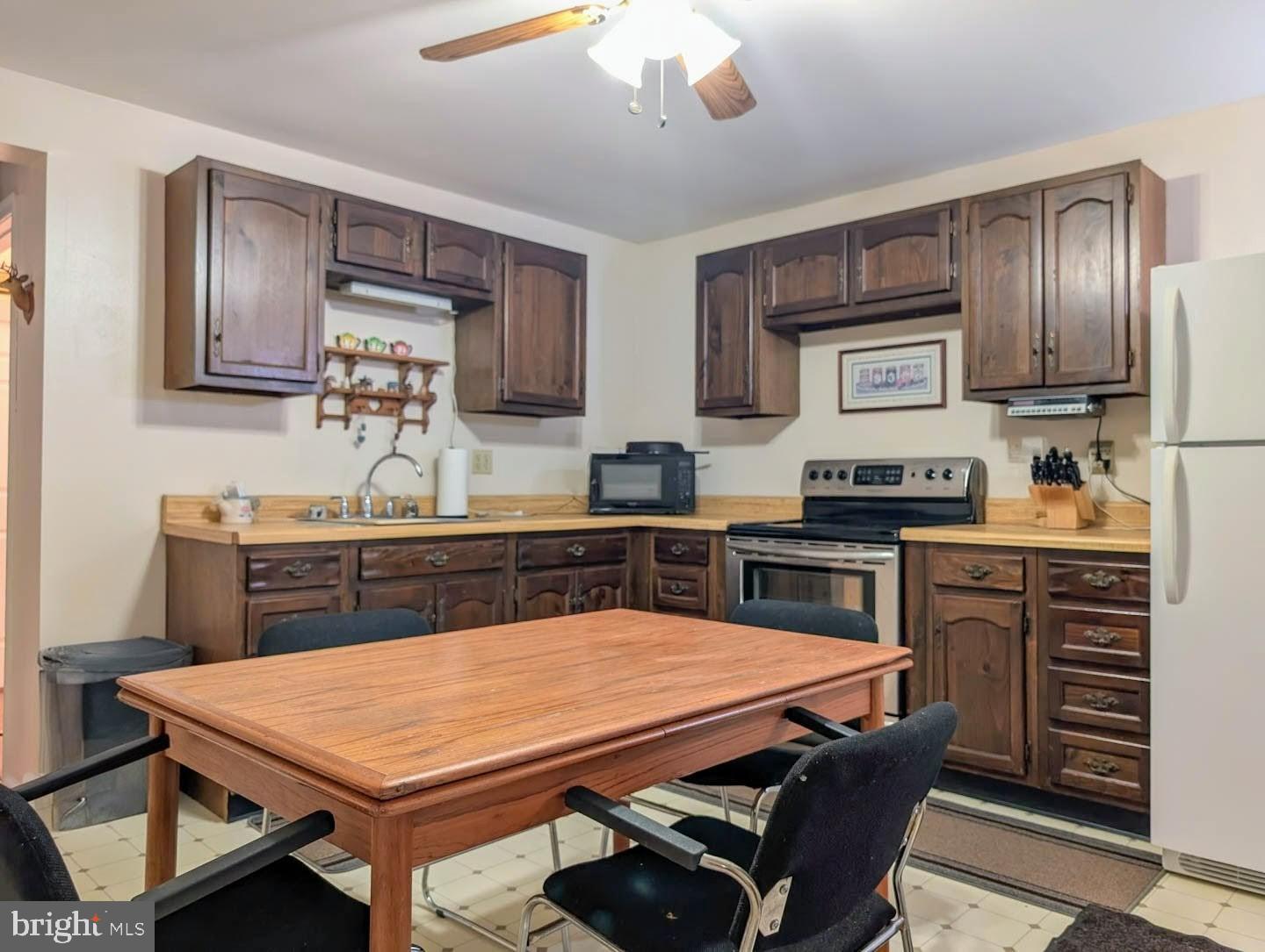939 Collins Road Artemas, PA 17211 - Photo 12 of 43 a kitchen with a table chairs microwave and cabinets