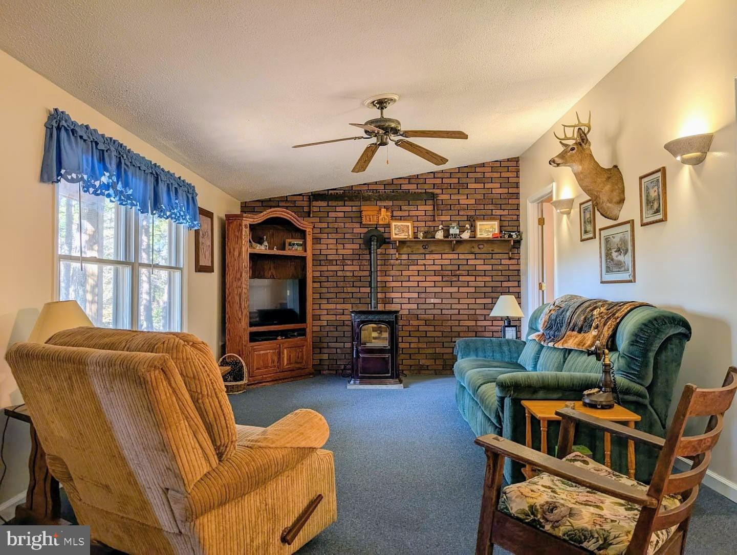 939 Collins Road Artemas, PA 17211 - Photo 8 of 43 a living room with furniture a fireplace and a flat screen tv
