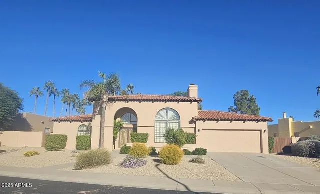 a view of a white house with large windows and a clock on the top