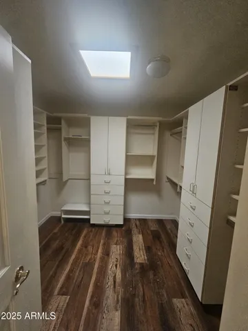 a view of walk in closet with wooden floor