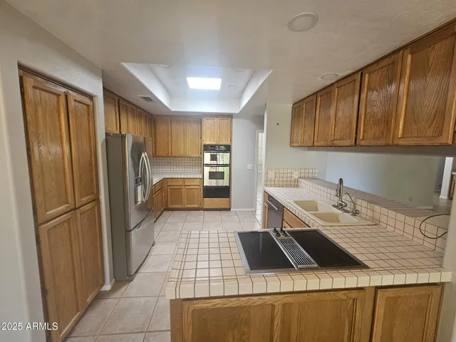 a kitchen with a refrigerator sink and cabinets