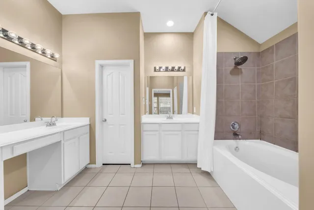 a bathroom with a bathtub a mirror a double vanity sink and vanity