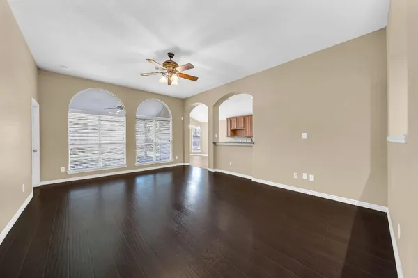 a view of an empty room with a window and wooden floor