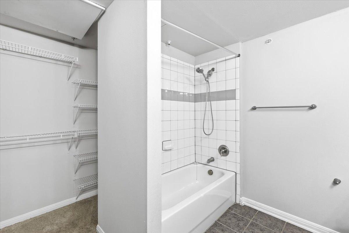 2502 Leon Street, Unit 414 Austin, TX 78705 - Photo 14 of 21 a bathroom with a bathtub and a shower