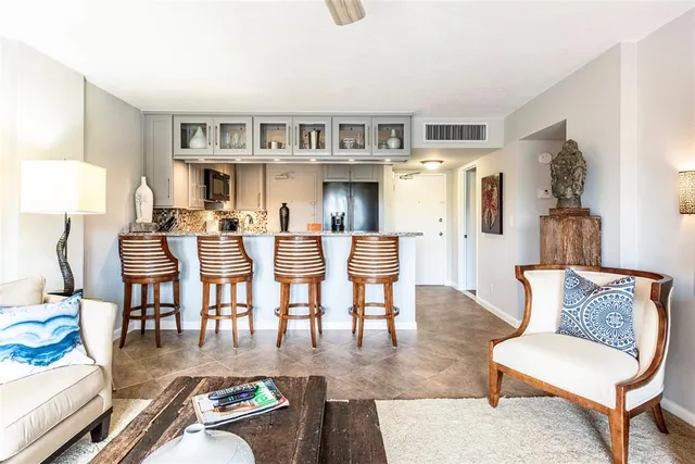 a living room with furniture and a dining table with kitchen view