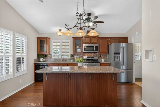 a kitchen with stainless steel appliances granite countertop a sink a stove and a refrigerator