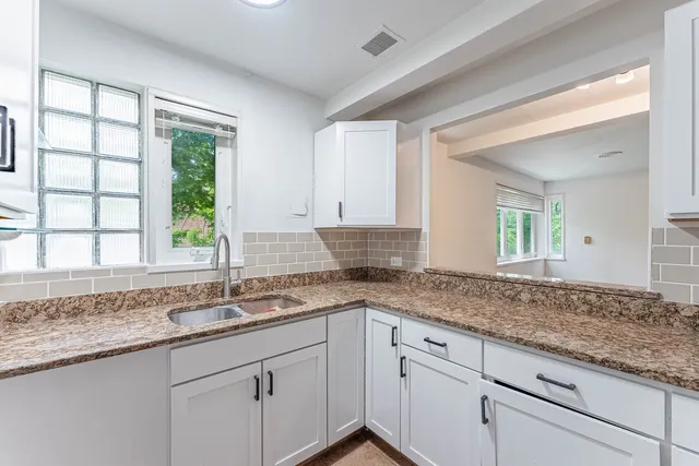a kitchen with granite countertop sink and window