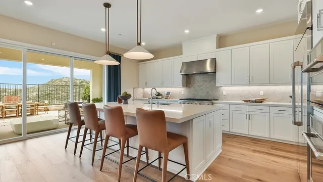 a kitchen with kitchen island granite countertop a table chairs sink and cabinets