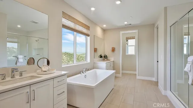 a bathroom with a double vanity sink a mirror and a bathtub