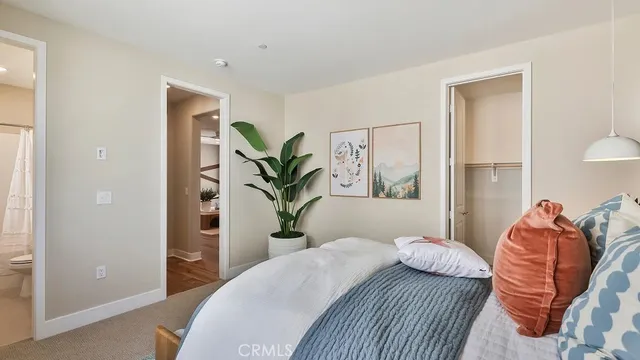 a bedroom with a large bed and a potted plant