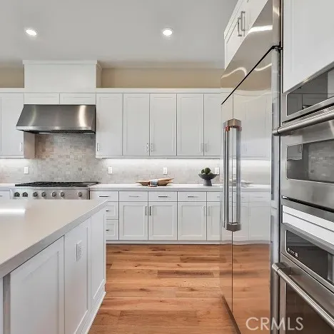 a kitchen with granite countertop white cabinets and stainless steel appliances