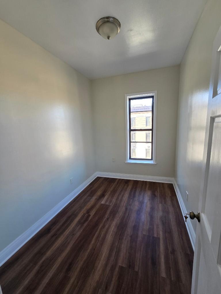 754 Park Place, Unit 9 Brooklyn, NY 11216 - Photo 5 of 6 an empty room with wooden floor and windows